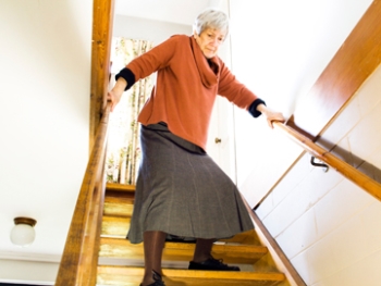 Senior woman walking down stairs.